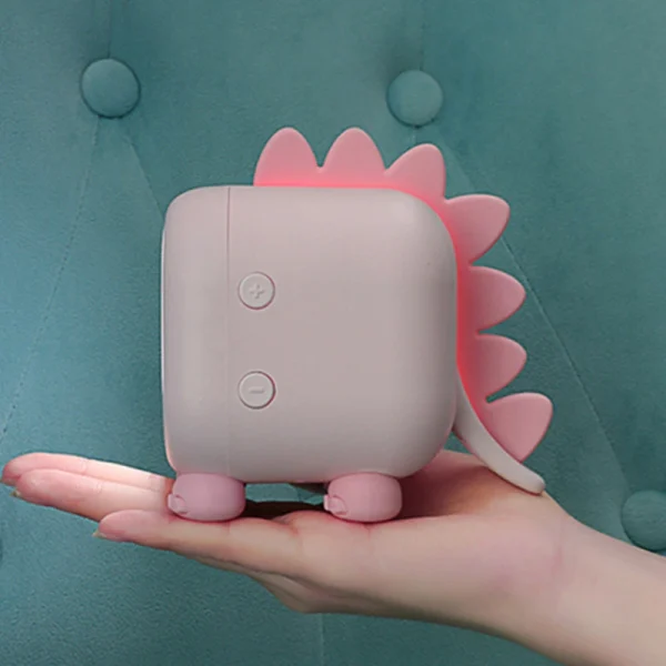 Réveil enfant dragon rose poudré veilleuse vue de côté Réveil enfant dragon rose poudré avec veilleuse allumée et boutons latéraux