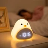 Réveil enfant oiseau veilleuse nuit table de chevet Réveil enfant oiseau avec veilleuse chaude allumée sur une table de chevet