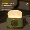 Réveil enfant toast veilleuse douce vert tendre Réveil enfant toast vert tendre avec veilleuse douce allumée sur une table de nuit